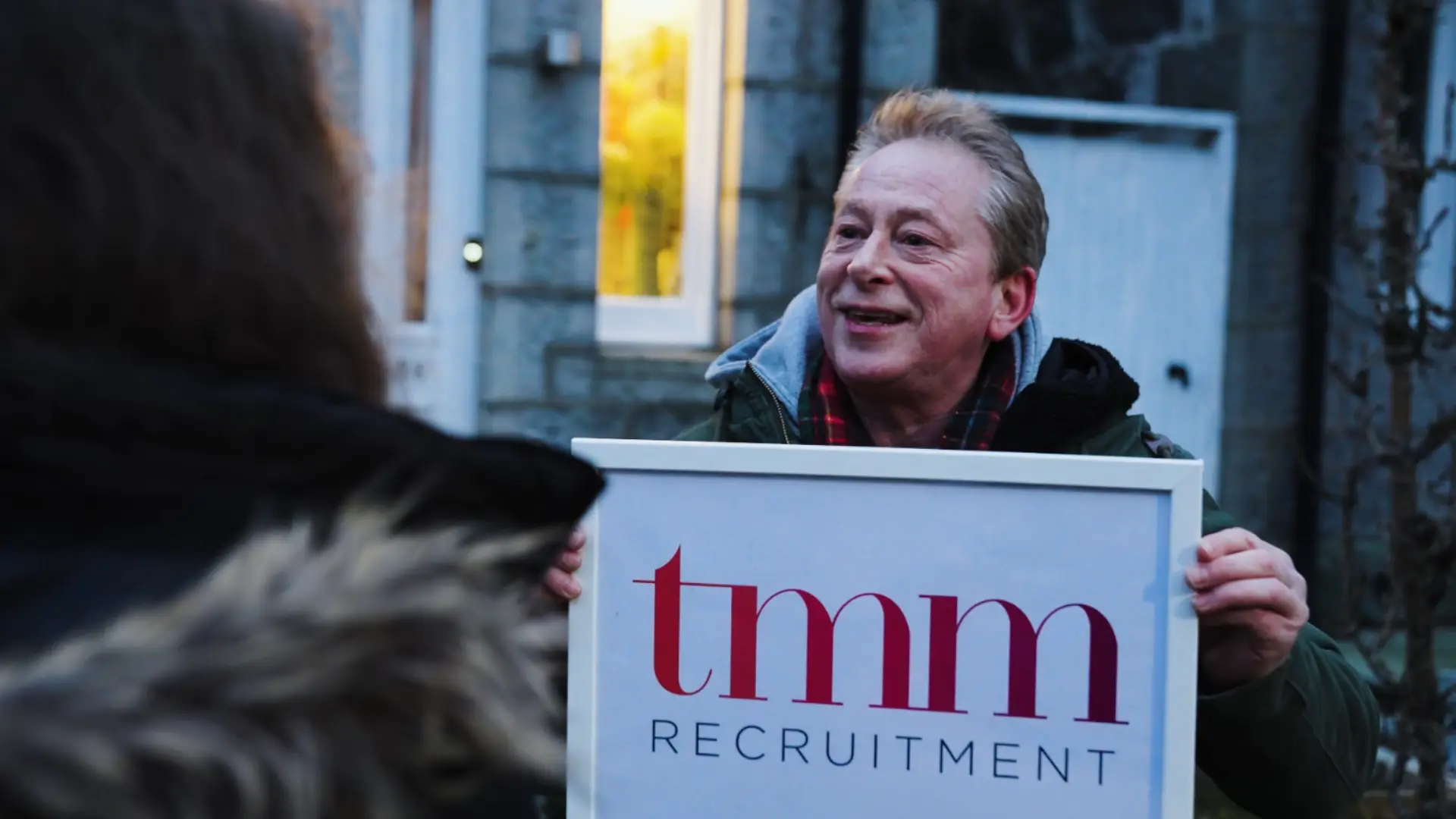 Video Thumbnail for TMM Recruitment Christmas video Aberdeen. Man holding a 'Love Actually' themed sign and showing it to a girl.