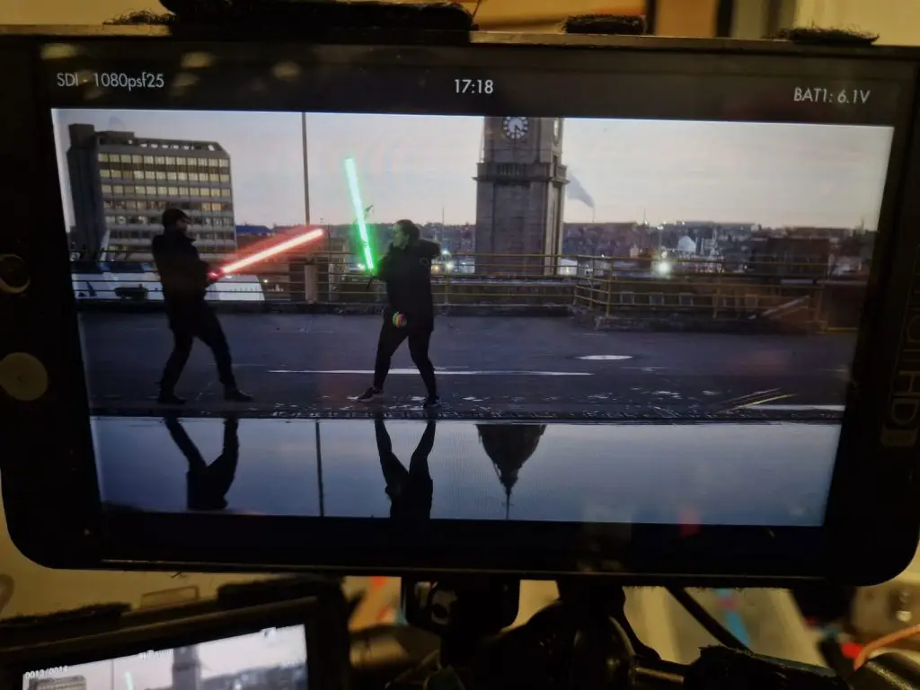 Erin and Director having a lightsaber fight with lighting tubes on roof in Aberdeen